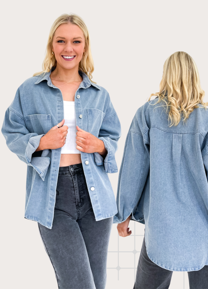 A female model wearing a black denim shacket over a white top and blue jeans. The shacket features side splits and functional front buttons.